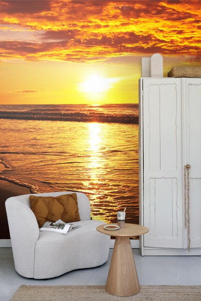 Wohnraum mit Fototapete mit Meeresmotiv, Sessel und Beistelltisch.