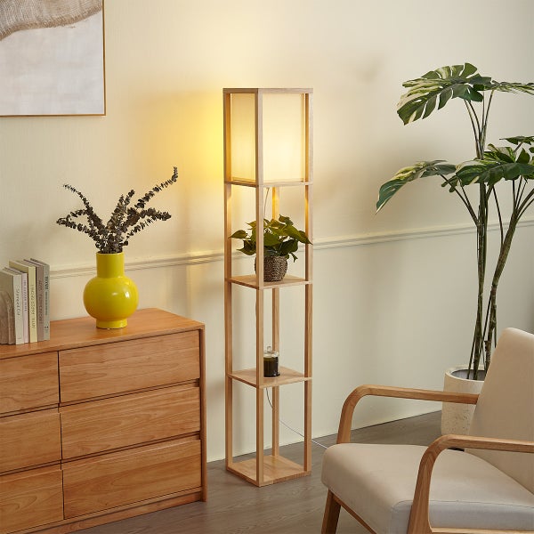 Moderne Stehlampe aus Holz mit integrierten Ablageflächen und Stoffschirm in einem gemütlich eingerichteten Wohnbereich mit Zimmerpflanzen.