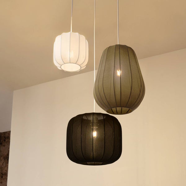 Drei Hängeleuchten mit verschieden geformten Textilschirmen in unterschiedlichen Höhen.