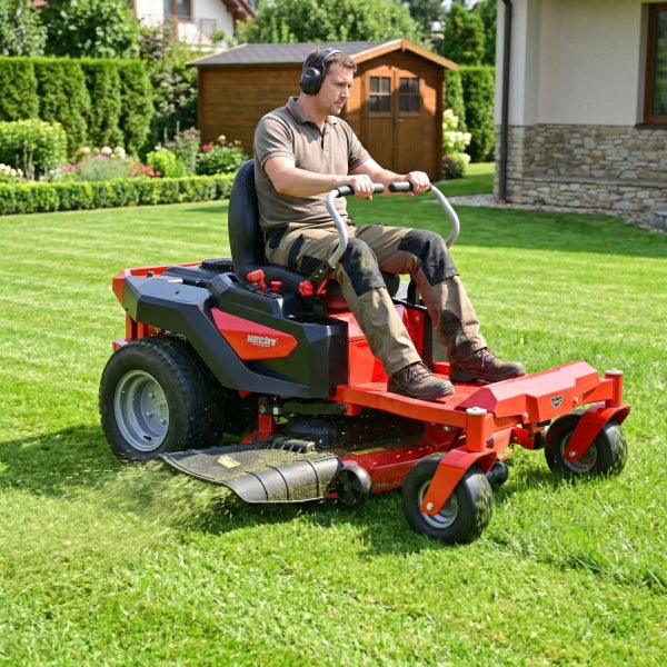 Mann fährt Rasenmäher auf Rasenfläche