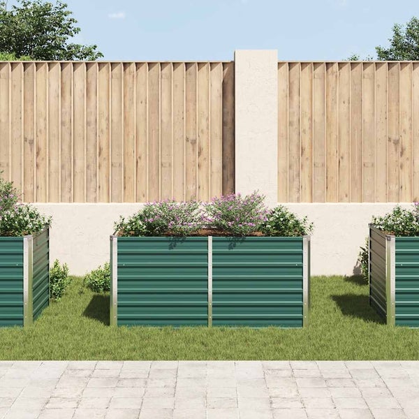 Drei grüne Hochbeete mit Pflanzen im Garten vor Holzzaun.