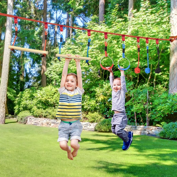 Zwei Kinder spielen auf einer Outdoor-Spielanlage mit Slackline, Sprossen und Ringen im Garten.