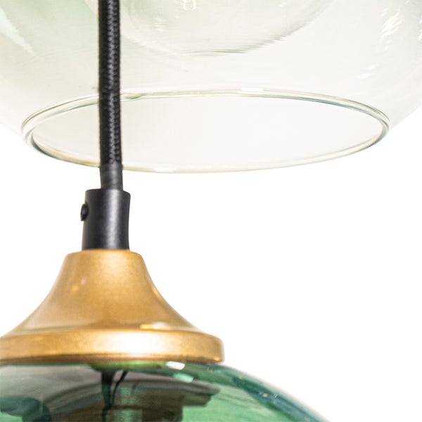 Detailaufnahme einer Hängelampe mit Glasschirm und goldfarbener Fassung