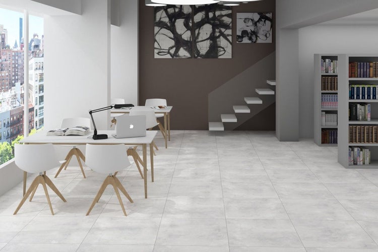 Heller Büroraum mit Schreibtischen, Stühlen, Bücherregal und Kunstwerken