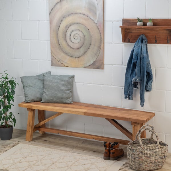 Eingangsbereich mit Holzbank, Kissen, Wanddekoration und Accessoires für einen einladenden Look