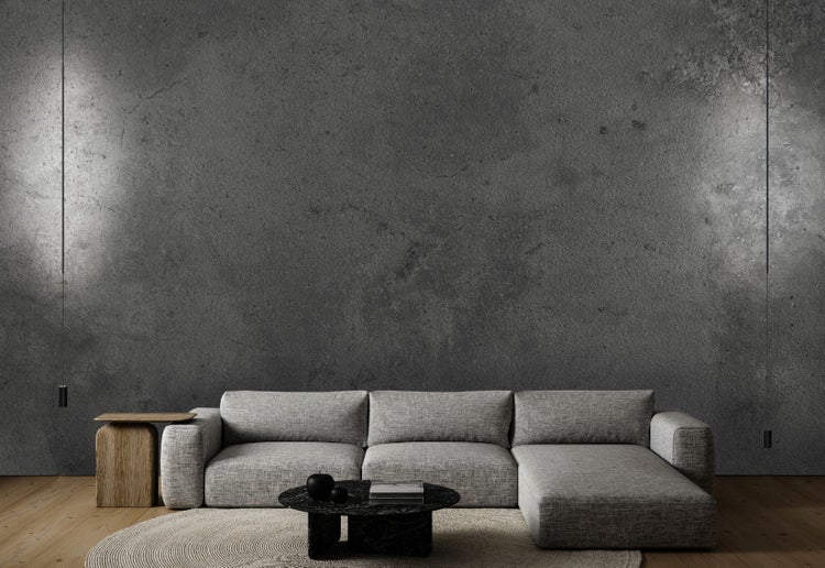 Wohnzimmer mit modularem Sofa, Couchtisch, Beistelltisch und Teppich vor einer Betonwand