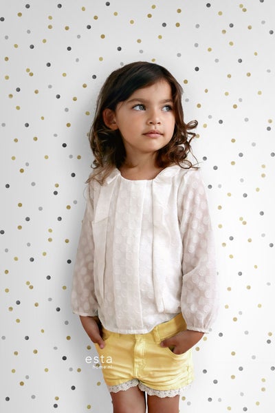 Mädchen vor Wand mit Punktmuster