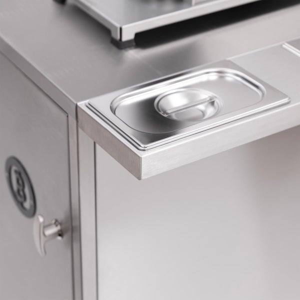 Olivenbäume mit dicken Stämmen in schwarzen Kunststofftöpfen auf einer Freifläche einer Baumschule.