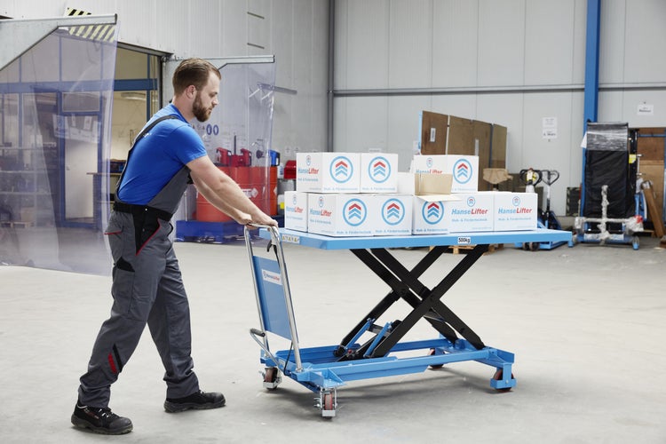 Mann schiebt Hubtischwagen mit HanseLifter Kartons in einem Lager