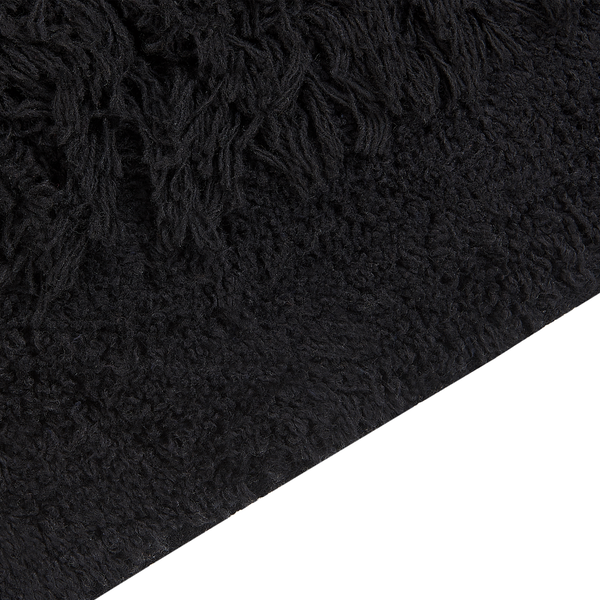 Nahaufnahme eines schwarzen Hochflor-Teppichs mit weicher Textur.