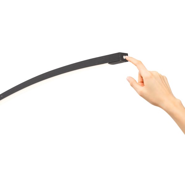 Eine Hand bedient den Tastschalter an einer gebogenen schwarzen LED Leuchte.