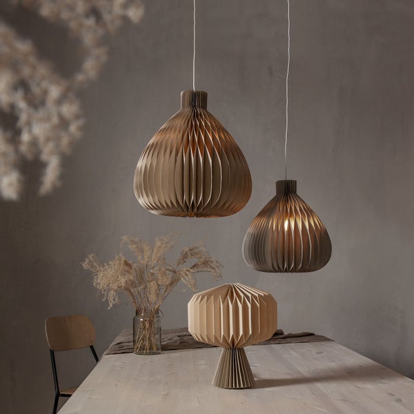 Szene mit zwei Papier-Hängeleuchten und einer Papier-Tischleuchte auf einem Tisch