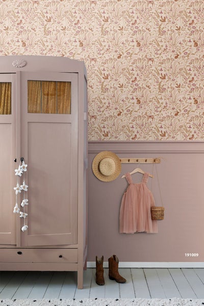 Vliestapete mit Waldtiermotiv über einer altrosa Wandpaneele neben einem Schrank im Kinderzimmer.
