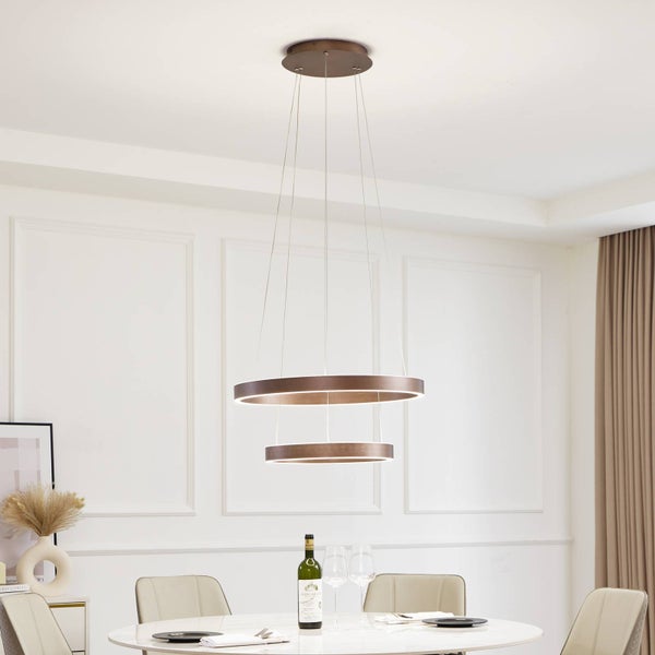 Moderne zweistufige Ring-Pendelleuchte aus braunem Metall über einem Esstisch in einem hellen, organisierten Zimmer mit Wandleisten.