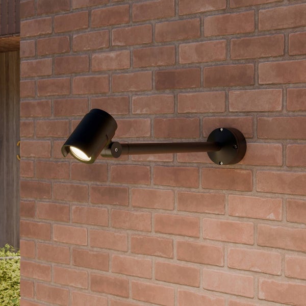 Schwarzer Außenstrahler mit verstellbarem Kopf, montiert an einer Ziegelwand mittels Wandarm.