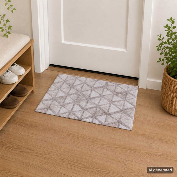 Fußmatte mit geometrischem Dreiecksmuster in modernem Eingangsbereich vor einer Zimmertür mit Schuhregal und Topfpflanze.