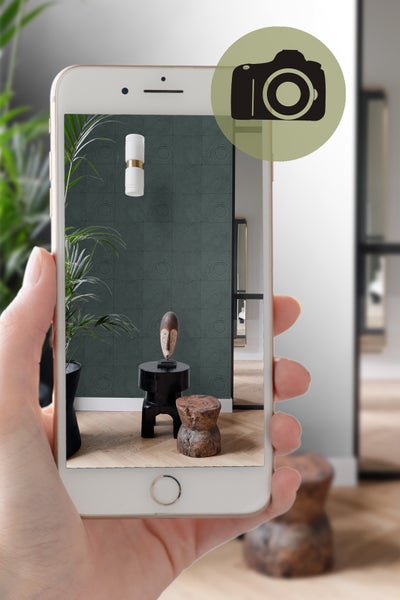 Einrichtungsbeispiel mit Mustertapete, Tisch und Dekoration im Smartphone betrachtet