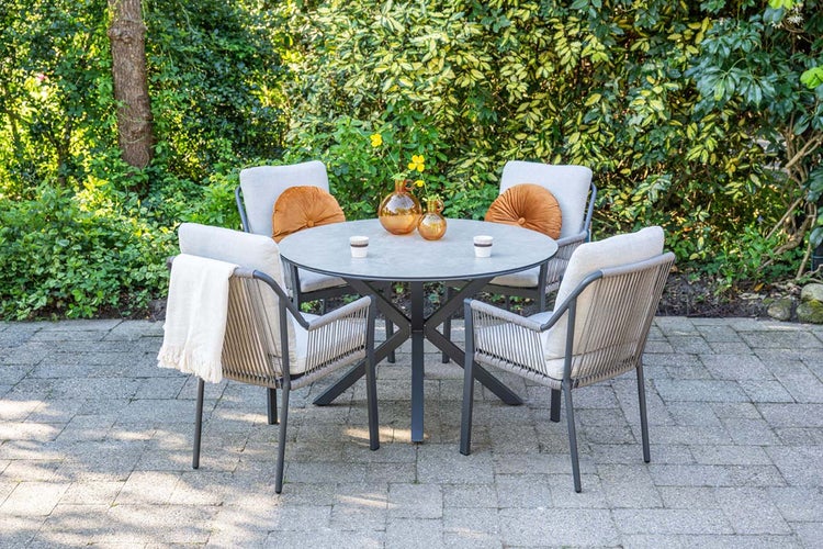 Gartenmöbel-Set mit rundem grauem Tisch und vier Gartenstühlen mit Seilgeflecht und Polstern auf einer Steinterrasse.