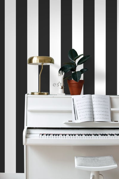 Szene mit weißem Klavier, Tischleuchte, Zimmerpflanze und gestreifter Tapete