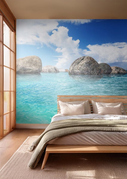 Schlafzimmer mit Fototapete, die eine Meereslandschaft mit Felsen zeigt