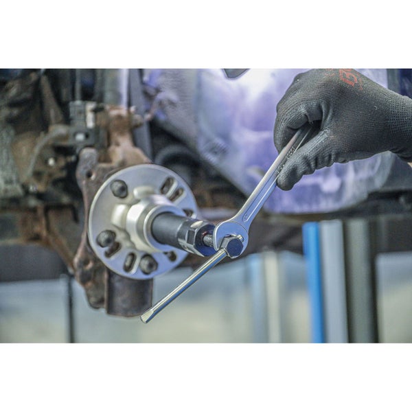 Hand mit Handschuh betätigt Drehmomentschlüssel an Radnabe