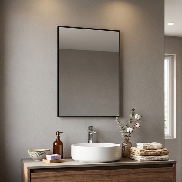 Rechteckiger Badspiegel mit schwarzem Rahmen über einem weißen Aufsatzwaschbecken und einem modernen Waschtisch aus Holz.