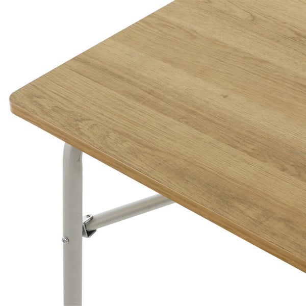 Detailansicht eines Klapptisches mit heller Holzplatte und silbernen Metallbeinen, die den Klappmechanismus zeigt.