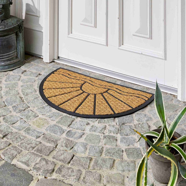 Halbrunde Fußmatte aus Kokosfaser mit Sonnenmuster vor einer Haustür