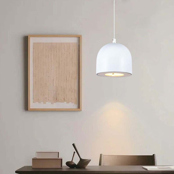 Szene mit weißer Hängelampe über einem dunklen Holztisch und einem gerahmten Bild an der Wand