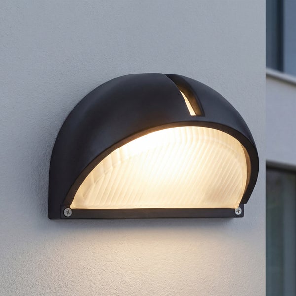 Halbkreisförmige Außenwandleuchte mit strukturiertem Glasdiffusor für eine gleichmäßige Lichtverteilung an Fassaden.