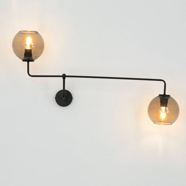 Wandleuchte mit zwei Glaskugeln an einem schwarzen Metallgestell