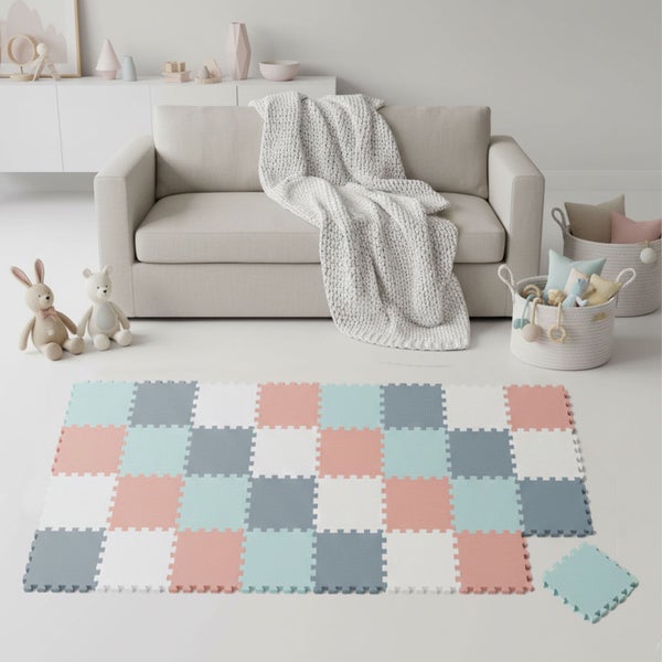 Puzzlematte aus Schaumstoff-Fliesen in Pastellfarben in einem hellen, organisierten Zimmer mit Sofa, Kuscheltieren und geflochtenen Körben.