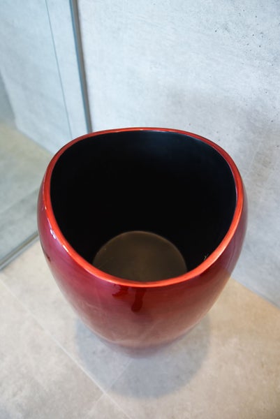 Rote, ovale Bodenvase mit schwarzer Innenseite und glänzender Oberfläche.