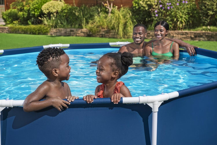 Familie mit zwei Kindern in einem runden Aufstellpool mit weißem Rahmen im Garten.