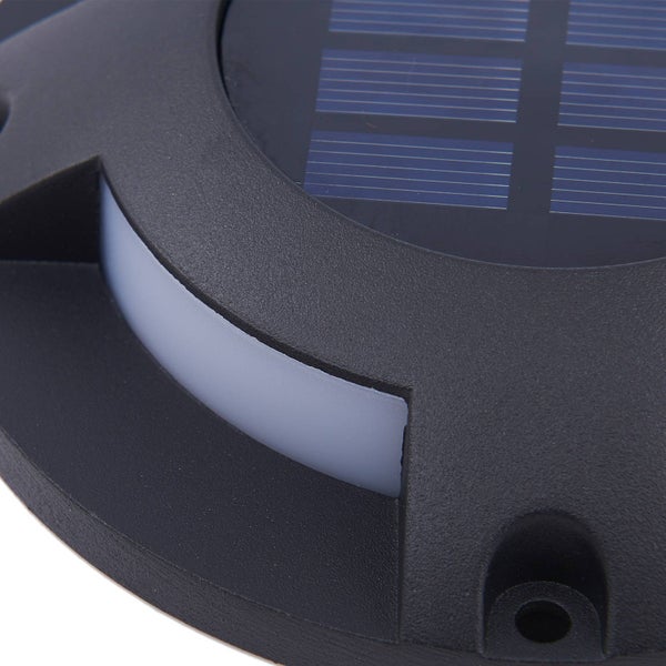 Nahaufnahme einer runden Solar-Bodenleuchte mit integriertem Solarpanel und weißem Lichtaustritt.