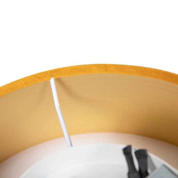 Detailansicht eines senfgelben Lampenschirms aus samtartigem Textil mit weißem Innengestell.