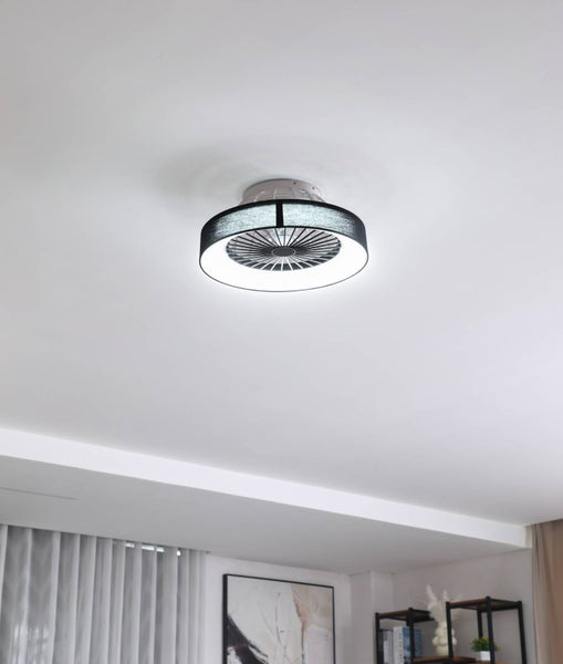 Moderner Deckenventilator mit integriertem LED-Lichtring und dunklem Textilschirm in einem hellen Wohnraum.