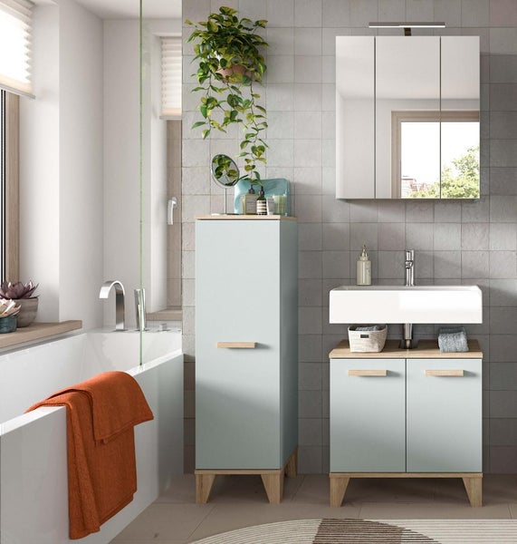 Modernes Badezimmer mit Waschtischunterschrank, Hochschrank und Spiegelschrank in hellen Farbtönen und Holzoptik vor gefliester Wand.