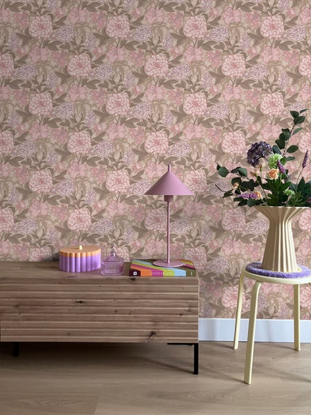 Einrichtungsgegenstände in einem Zimmer mit floraler Tapete