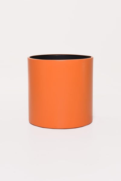 Zylindrischer Übertopf in Orange für Zimmerpflanzen mit glatter Oberfläche.