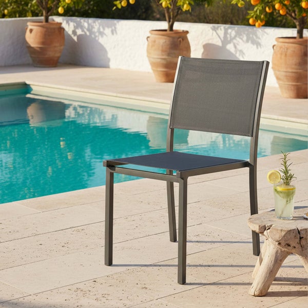 Moderner Gartenstuhl mit Metallgestell und Textilbespannung auf einer Steinterrasse an einem Pool.