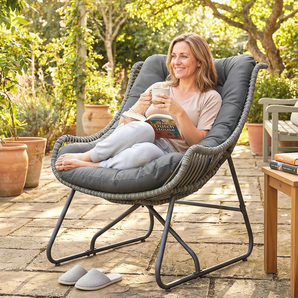 Moderner Garten-Lounge-Sessel mit Seilgeflecht und grauem Polster auf einer sonnigen Terrasse.
