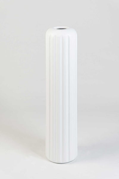 Hohe weiße zylindrische Vase mit geriffelter Oberfläche.