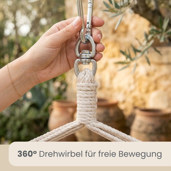 Hand befestigt Metallkarabiner an einem 360 Grad Drehwirbel für Hängesessel mit dickem Seil für freie Beweglichkeit.