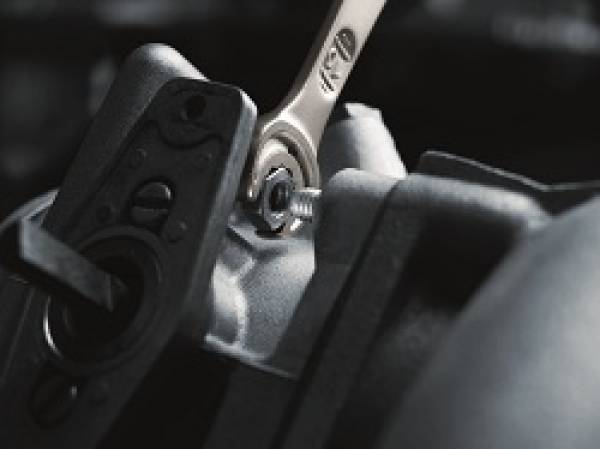 Ein Schraubenschlüssel zieht eine Mutter an.