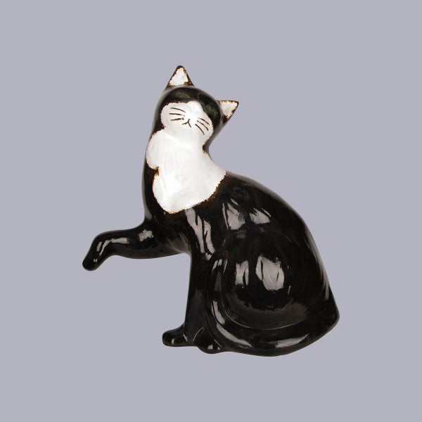Dekorationsfigur Katze aus glänzender Keramik in Schwarz und Weiß, sitzend mit erhobener Pfote.