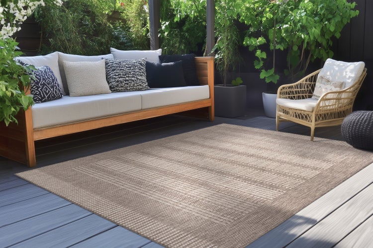 Outdoor Teppich mit modernem Webmuster auf einer Holzterrasse mit Lounge Bereich.