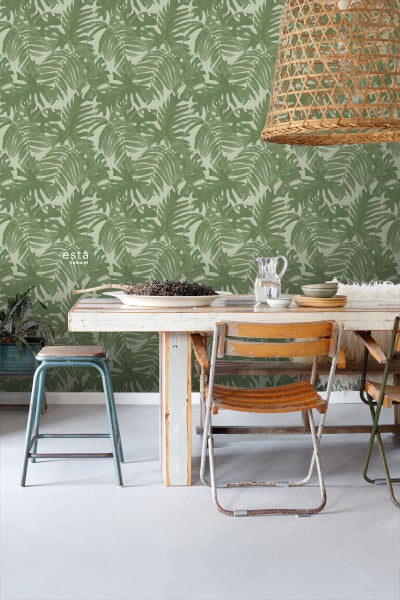 Wohnraum mit grüner Blättertapete, Esstisch und Lampe