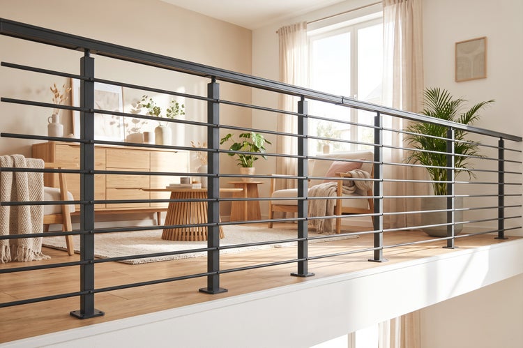 Modernes Treppengeländer aus Metall mit horizontalen Stäben, installiert als Absturzsicherung auf einem Wohnbereichsbalkon in einem hellen Raum.