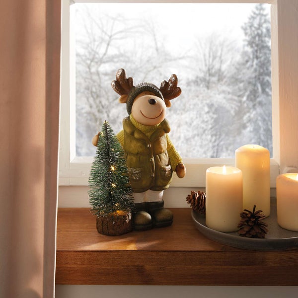 Dekorative Fensterbank mit Elchfigur, kleinem Tannenbaum und Kerzen